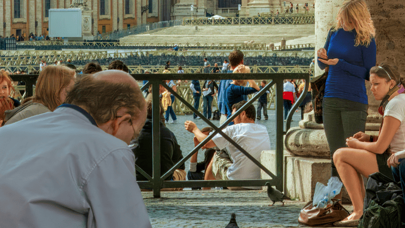 Pellegrini in preghiera davanti alla Basilica di San Pietro, immersi nel silenzio e nella meditazione durante il Giubileo a Roma