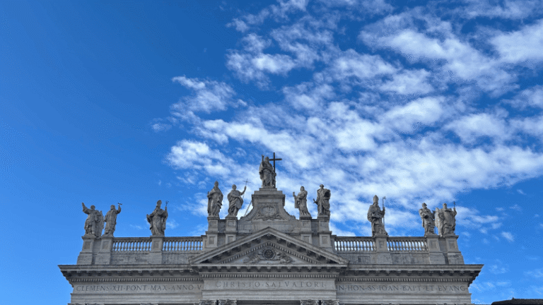 Facciata della Basilica di San Giovanni in Laterano a Roma, sormontata da statue di Cristo e dei santi, icona spirituale per i pellegrini del Giubileo