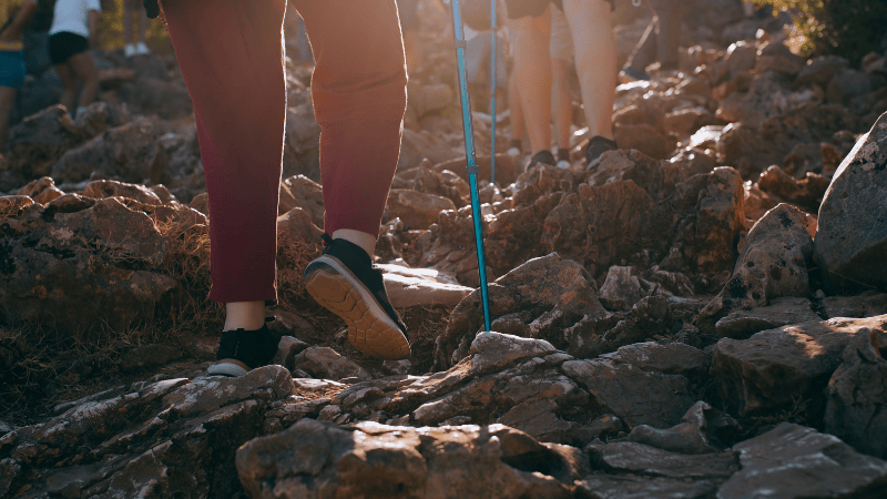 Pellegrini in cammino sui sentieri rocciosi verso il Podbrdo di Medjugorje, luogo di risveglio spirituale e conversione personale.