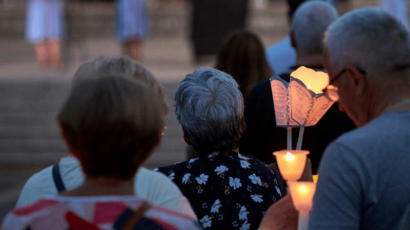 Pellegrini partecipano alla suggestiva Processione aux Flambeaux di Lourdes, illuminata dalle fiaccole accese nella notte