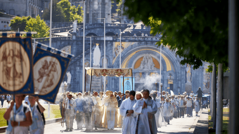 Solenne Processione del Santissimo Sacramento davanti alla Basilica di Lourdes, un momento sacro e coinvolgente.