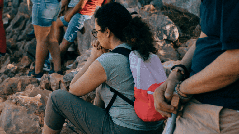 Una donna assorta nella preghiera personale a Medjugorje, durante un momento spirituale intenso nel cammino comunitario