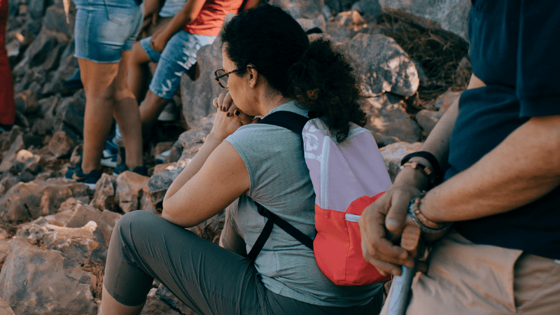 Una donna assorta nella preghiera personale a Medjugorje, durante un momento spirituale intenso nel cammino comunitario