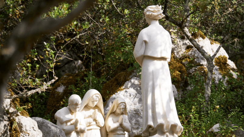 Sculture in marmo che raffigurano l’apparizione dell’Angelo della Pace ai tre pastorelli di Fatima, immerse nel verde del luogo dell’apparizione a Loca do Cabeço, Aljustrel