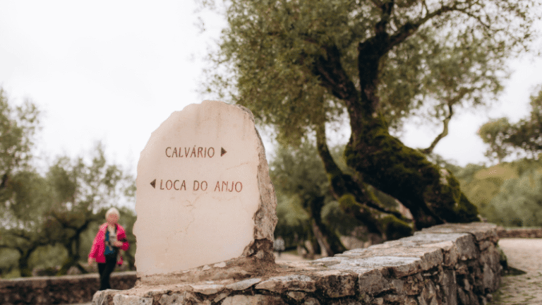 Segnaletica in pietra tra gli ulivi e i muretti di Valinhos indica il cammino verso il Calvário e la Loca do Anjo, luoghi legati alle apparizioni dell’Angelo a Fatima.