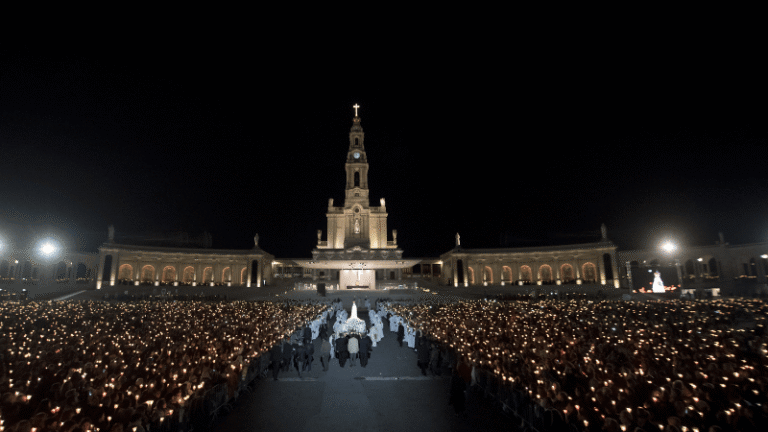 Processione notturna al Santuario di Fatima, con migliaia di pellegrini che tengono candele accese davanti alla Basilica di Nostra Signora del Rosario.