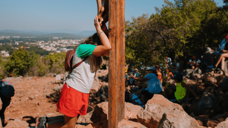 Momento di preghiera e guarigione spirituale a Medjugorje: pellegrini cercano pace alla croce