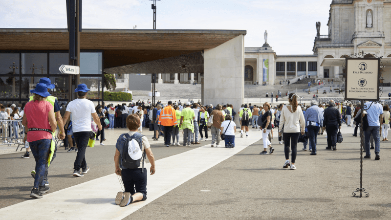 donna in ginocchio in preghiera santuario pellegrinaggio